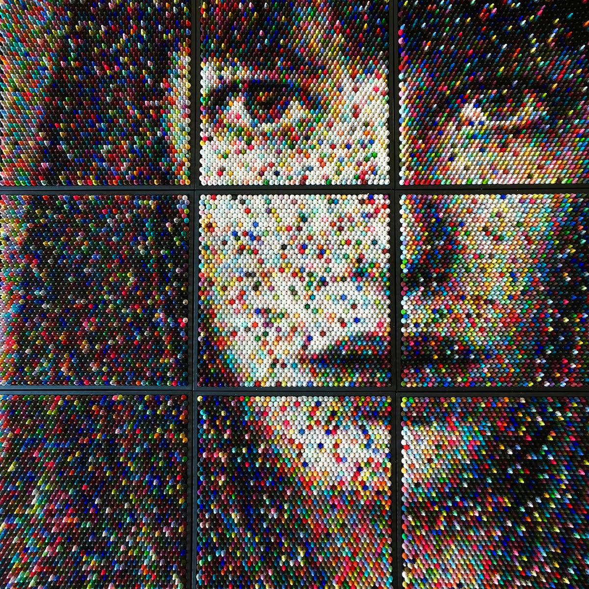 An example of Art Materialism - a face emerging from countless stacked crayons by artist Christian Faur