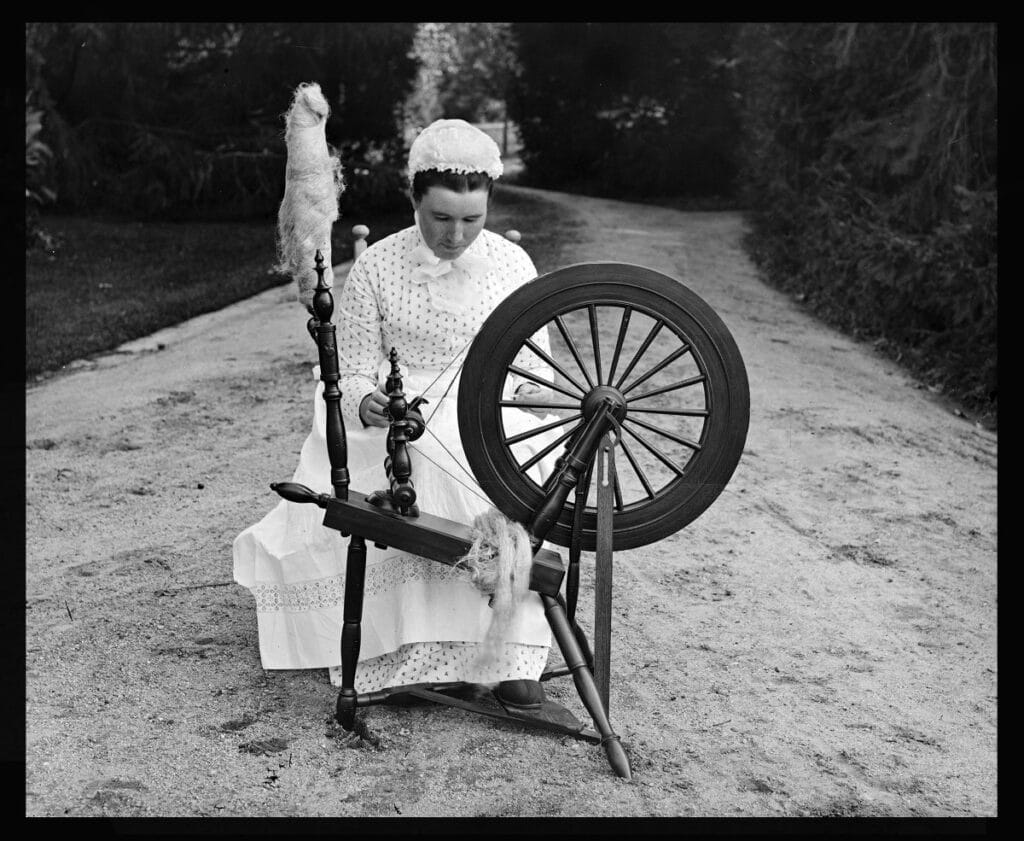 Woman from 19th century Massachusetts sitting at a sewing machine